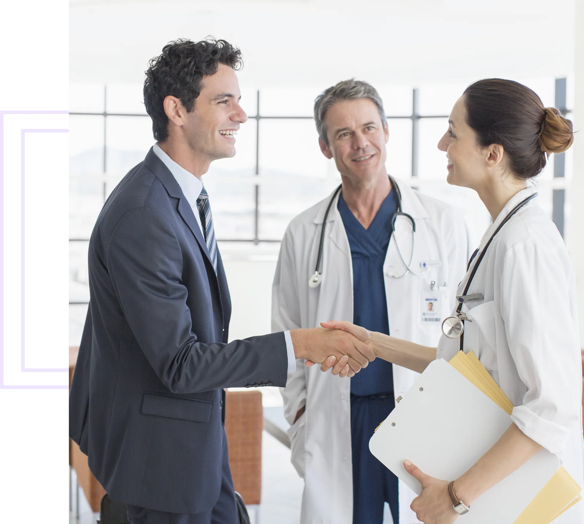 Businessman and doctors shaking hands, smiling.
