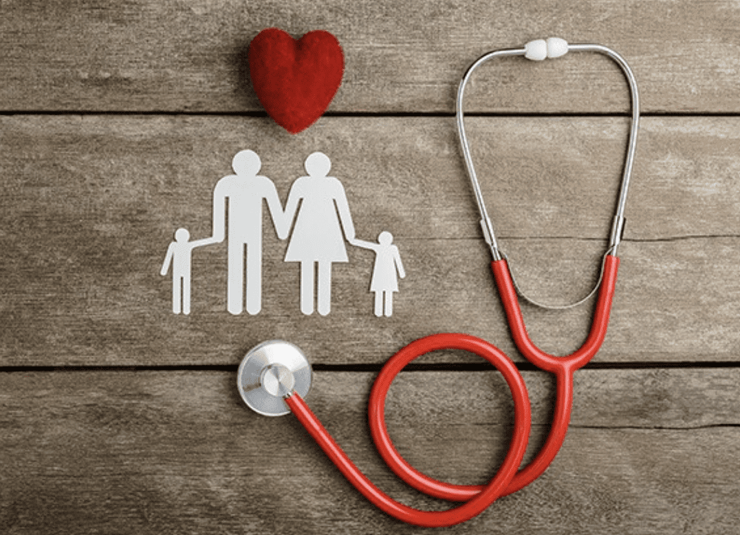 Red stethoscope with paper family cutout and heart on wooden background.