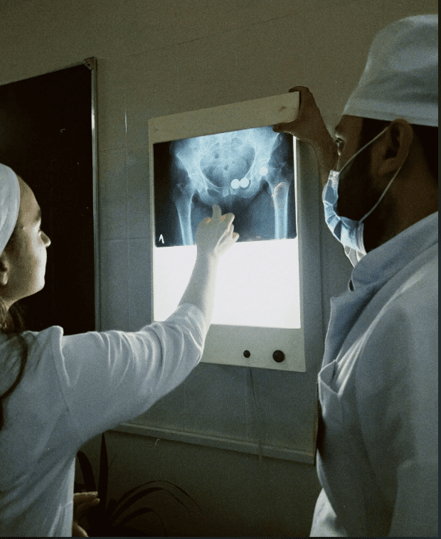 Two medical professionals examining an X-ray image.